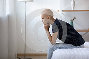 Pensive young woman with bald head ponder on cancer treatment