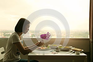 Pensive young woman dinner alone in the room.