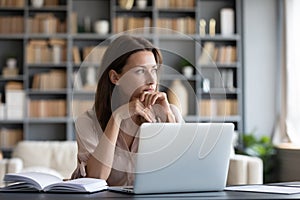 Pensive young woman distracted from work thinking