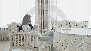 Pensive young woman drinks tea in pajamas in the morning. Young beautiful girl with a cup in her hands thoughtful. In