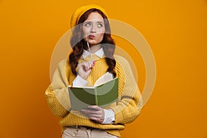 Pensive young woman with long red hair in sweater