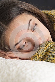 Pensive young woman lying on couch