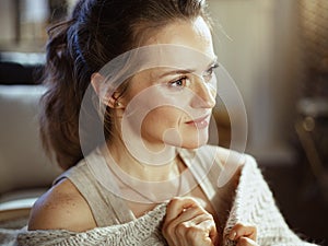 Pensive young woman at modern home in sunny autumn day