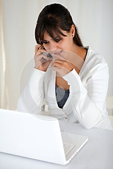 Pensive young woman reading on laptop screen