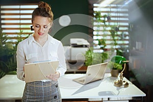 pensive young woman real estate agent in modern green office