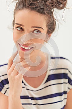 Pensive young woman smiles to a side