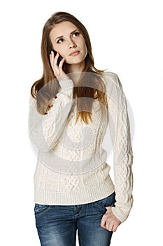 Pensive young woman talking on cell phone