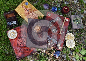 Pentagram, magic book of spells, pentagram and witch objects on the grass