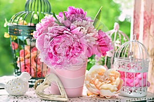 Peony bunch in vase on the table in the garden