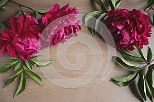 Peony flowers and old book on vintage wooden background