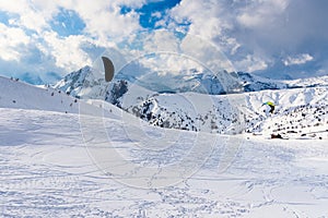 Peope snowkiting in a breathtaking witer mountain scenery photo