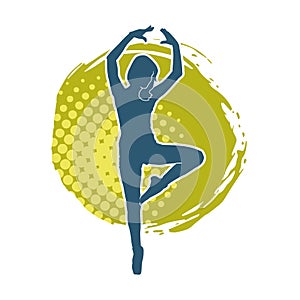 Silhouette of a female ballet dancer in action pose.