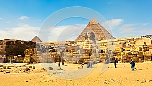 People admire the greatness of the stone Sphinx, pyramids and ancient architecture of Giza Plateau in Egypt