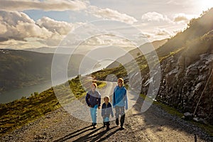 People, adult with kids and pet dog, hiking mount Hoven, enjoying the splendid view over Nordfjord from Loen skylift