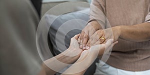 people, age, family, care and support concept - close up of senior and young woman holding hands