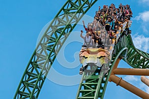 People amazing terrific Cheetah Hunt rollercoaster on lightblue cloudy sky background 71