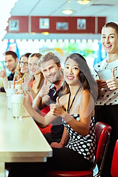 People in American diner or restaurant with milk shakes