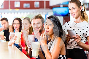 People in American diner or restaurant with milk shakes