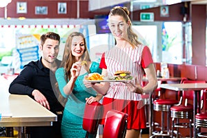 People in American diner or restaurant and waitress photo