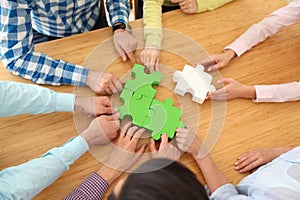 People assembling jigsaw puzzle