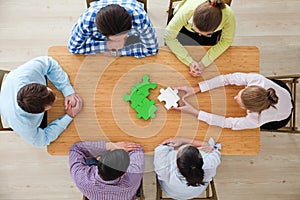 People assembling jigsaw puzzle