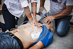 People assisting an unconscious man