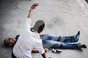 People assisting an unconscious man