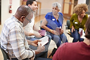 People Attending Bible Study Or Book Group Meeting In Community Center