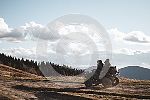 People on ATV are driving offroad in mountains during autumn sunny day