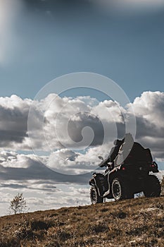 People on ATV are driving offroad in mountains during autumn sunny day