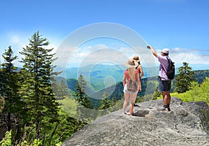 People with backpacks hiking on summer trip in mountains.