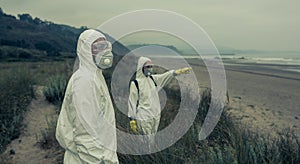 People in bacteriological protective suits watching the sea