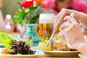 People in bavarian Tracht eating in restaurant or pub photo
