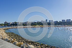 People on the beach, sunbathing and swimming, enjoying on vacation.