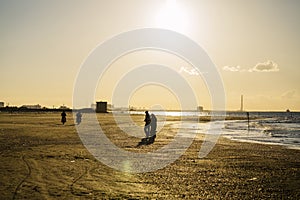 People on the beach at the sunset time