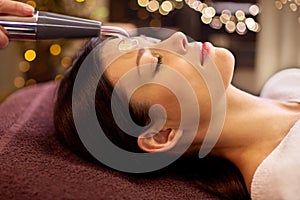 Woman having hydradermie facial treatment in spa photo