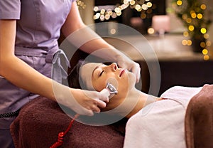 Woman having hydradermie facial treatment in spa photo