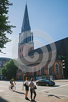 people and bicycler on street near church