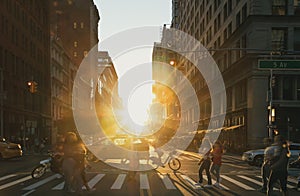 People, bikes and taxis in a busy intersection on 5th Avenue in New York City with sunset shining in the background