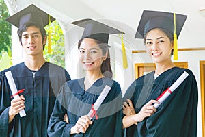 People with black graduation gowns hold diploma