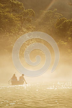 people boating in river with mist in summer