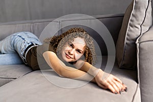 people, boredom and depression concept. Young woman with laptop computer lying on sofa at home
