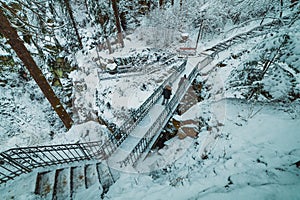 people on the bridge in the snowy mountain park