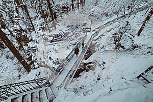 people on the bridge in the snowy mountain park