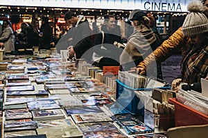 People browsing books at second hand book market in Southbank, London, UK, in the evening