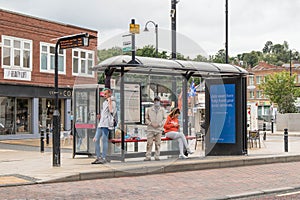 People at Bus Stop, man wearing mask waitng for bus public transport