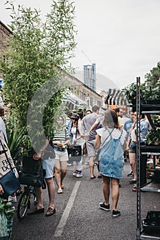 People buying plants and flowers at the Columbia Road Flower Market, London, UK.