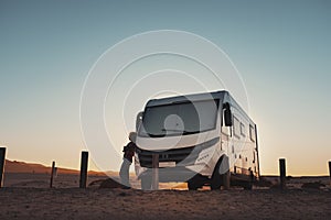 People and camper camping car van freedom concept lifestyle or alternative transport vacation. Big van parked off road and woman