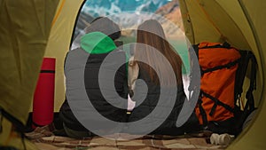 People on campsite traveling and hiking, exploring nature. Young loving couple sitting inside the tent at lake coast in