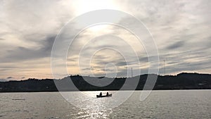 People Canoeing on River in the lake at Sunset, Sangkhla Buri,Kanchanaburi, Thailand.